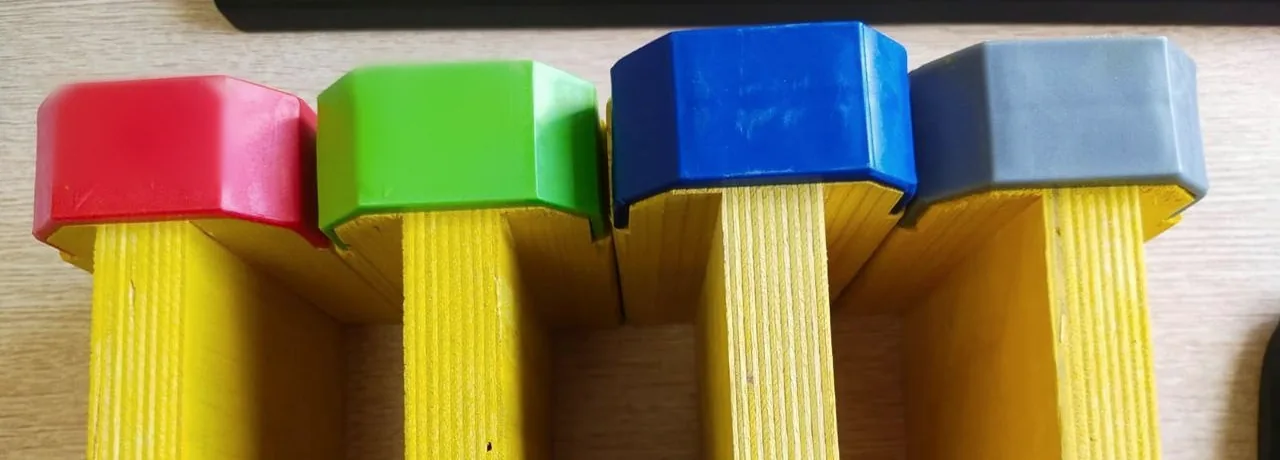 Four girder ends side by side fitted with polymer end caps in red, green, blue and grey